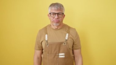 Depresyondaki orta yaşlı adam, gri saçlı ve gözlüklü, sarı arka planda tek başına duruyor. Korkunç bir jest yapıyor, silahı kafasına doğrultuyor, hayal kırıklığına uğramış ve intihara meyilli..