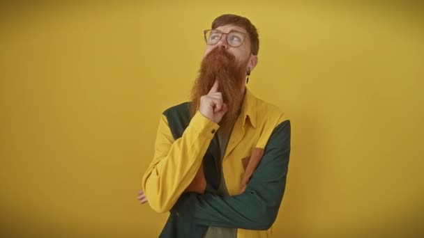 高価な若い赤毛の男 ガラスがつまずき 指に横たわり 黄色で一人で立っている 上を目指す彼の思慮深い目 興味深いパズルを掘り下げる — ストック動画