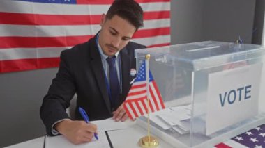 Takım elbiseli genç bir İspanyol Amerikan bayraklı bir seçim merkezinde oy veriyor.