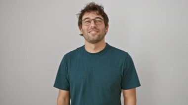İspanyol gözlüklü, gülümseyen ve yan tarafı işaret eden bir adam, izole edilmiş beyaz bir duvara başparmakla ürününü gösteriyor.