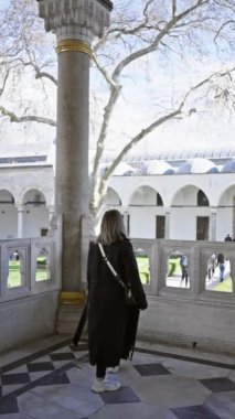 Zarif giyimli bir kadın İstanbul 'daki Topkapı Sarayı' nın mimari detaylarına hayran..