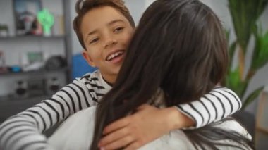 Gülümseyen bir çocuk, sıcak bir ev ortamında, sıcaklığı ve aile bağını yansıtan bir kadını kucaklar..