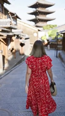 Neşeli, güzel İspanyol kadın Kyoto 'nun eski lejyon sokağında gülerek, geleneksel ahşap pagoda önünde poz verirken pozitif duygular ve gerçek neşe yayıyor..