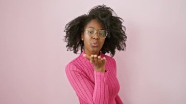 Gözlüklü, kendinden emin, neşeli bir gülümsemeyle uçan bir öpücük atan seksi Afrikalı Amerikalı kadın. Sevginin sevimli yüz ifadesi. Büyüleyici bir portre..