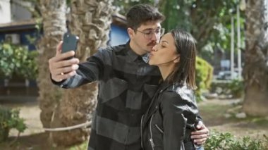 Bir kadın ve bir erkek kentin sokaklarında selfie çekiyorlar, neşe ve beraberlik yayıyorlar..