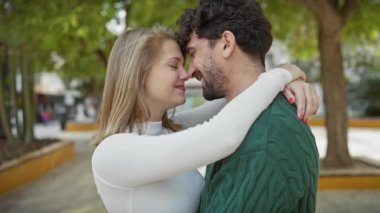Sevecen bir çift açık havada kucaklaşıyorlar. Şehirli bir sokakta sevgi ve mutluluk sergiliyorlar.