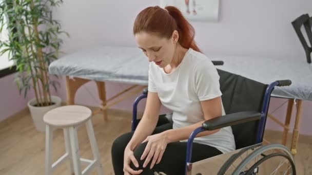 一个坐在轮椅上的年轻的高加索女人在疗养院里感到膝盖疼痛 — 图库视频影像