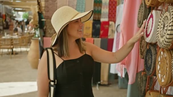 Een Glimlachende Vrouw Draagt Een Zonnehoed Winkels Voor Handtassen Een — Stockvideo