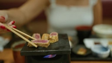 Lezzetli bir akşam yemeği, modern bir restoranda geleneksel Japon gyukatsu 'sunun tadını çıkaran genç bir kadın, kızarmış biftek tabağıyla hazırlanmış yemek, hazır yemek çubuklarını çıtır, pişmiş katsu için kullanmak,.