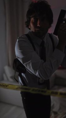 Pantolon askısı giymiş ciddi bir adam, karanlık ve derin bir atmosferi olan bir suç mahallinde dikkat bandından dolayı akranlık gösteriyor..