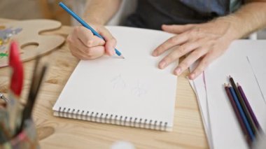 Sanat stüdyosunda sakallı beyaz bir adam, yaratıcılık ve konsantrasyon sergiliyor..