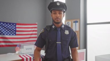 Bir Afro-Amerikan polisi, Amerikan bayrağı olan bir oy kullanma merkezinde 