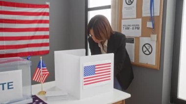 Afrikalı bir Amerikalı kadın, demokrasi ve vatandaşlık görevlerini temsil eden bir Amerikan seçim kurulunda güvenle oyunu kullanıyor..