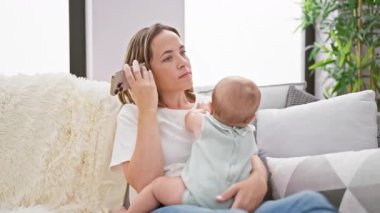Rahatlamış anne ve tatlı kızı evdeki koltukta oturmuş ciddi bir konuşma yaparken anne akıllı telefondan sesli mesaj gönderiyor.