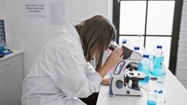 Νεαρή Ισπανίδα Επιστήμονας Εξετάζει Δείγματα Μικροσκόπιο Σύγχρονο Εργαστηριακό Περιβάλλον Ενσωματώνοντας — Αρχείο Βίντεο