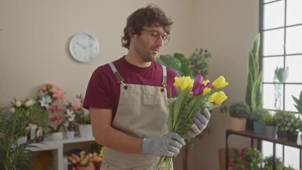 Glad Latinamerikansk Man Som Håller Tulpaner Ljus Blomsteraffär Omgiven Gröna — Stockvideo
