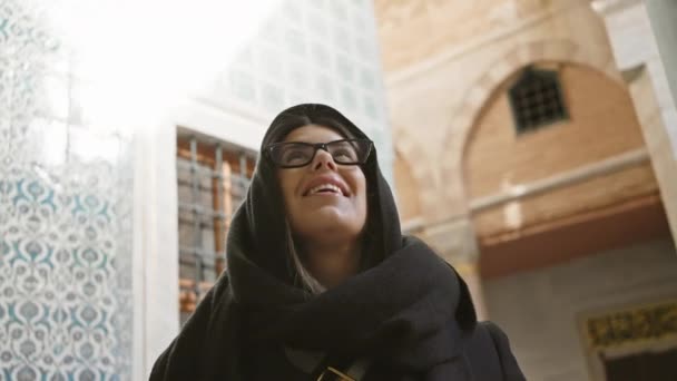 Eine Glückliche Frau Mit Brille Und Kopftuch Lächelt Während Sie — Stockvideo