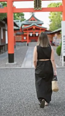 Güzel esmer, gözlüklü, esmer bir kadın, Fushimi inari-taisha 'da gündelik bir yürüyüşe çıkıyor, Japonya' nın kutsal kyoto türbesi, sırtına çarpıcı bir bakış açısı.