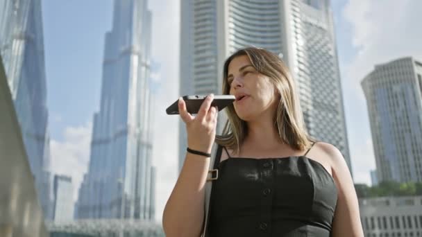Mujer Adulta Utiliza Teléfono Inteligente Para Comando Voz Con Rascacielos — Vídeos de Stock