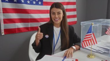 Neşeli genç İspanyol kadın Amerikan seçim masasında olumlu, kendinden emin bir onay işareti veriyor, neşeli gülüşü başarı ve iyi titreşimler saçıyor..