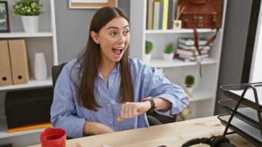 Genç ve güzel İspanyol kadın zaferi mutlu bir gülümsemeyle ve ofisteki kazanan ifadeyle kutluyor.