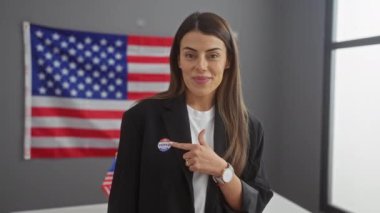 Gülümseyen İspanyol kadın 'Ben oy verdim' etiketini işaret ediyor, Amerikan bayrağı arka planında, demokratik katılımı sembolize ediyor.