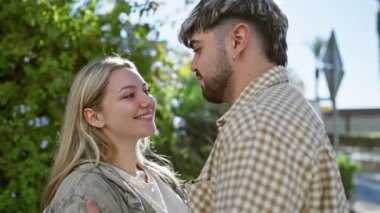 Sevgi dolu bir çift, yemyeşil bir şehir parkında sevgi ve yakınlık taşır..