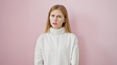 Huysuz, güzel sarışın, kuşkucu bakışları ve sinirli bakışları olan kız bir sorun yüzünden üzgün bir yüzle boğuşuyor. Pembe arkaplan negatif enerjiyi arttırır.