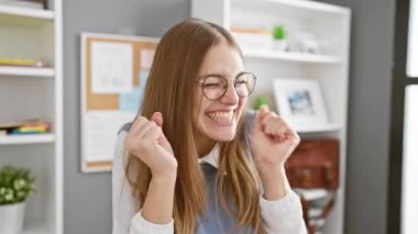 Heyecanlı bir galibiyet! neşeli genç sarışın iş kadını ofiste başarıyı kutluyor, kolları havada, gülümsüyor, gözleri kapalı - saf zafer!