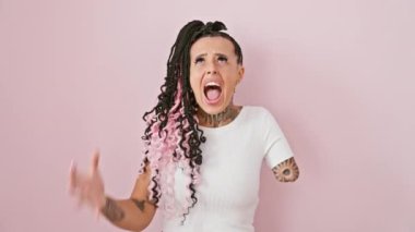 Pembe arka planda hayal kırıklığına uğramış İspanyol ampüte kadın, delilik ve öfke patlaması