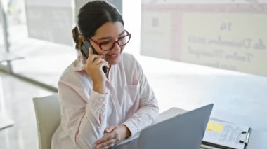 Modern ofis ortamında çalışan ve konuşan İspanyol kadın..