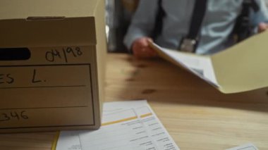 Polis departmanındaki belgeleri inceleyen adam, soruşturma ve suç analizi faaliyetleri öneriyor..