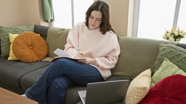 Mladá Běloška Píše Zápisníku Zatímco Sedí Doma Pohovce Laptopem Barevnými — Stock video