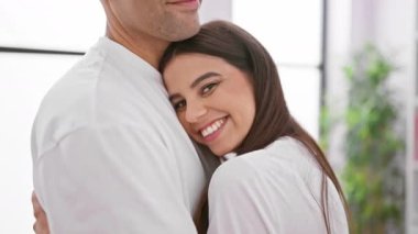 Sevgi dolu bir çift, aydınlık bir oturma odasında sarılır ve bir erkek ile bir kadın arasındaki sıcak, samimi ilişkiyi resmeder..