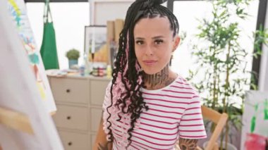 Stüdyoda oturan, neşeli şişirilmiş ağzıyla yanaklarını tüttüren, komik suratlı, sakat bir İspanyol kadın.