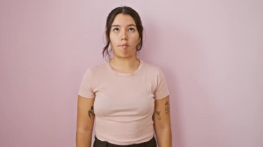 Çılgın eğlenceli, genç, güzel İspanyol kadın komik balık suratı yapıyor, şaşı bakıyor. Pembe izole arka planda aptalca bir poz veriyor, neşeli bir hareketle çılgın bir sevinç yaratıyor.