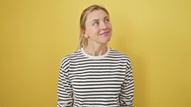 Neşeli genç sarışın kadın, kameraya seksi bir bakışla göz kırpıyor. Mutlu yüzü izole edilmiş sarı arkaplanı aydınlatıyor. O, doğal başarı ve pozitifliğin bir örneği.!