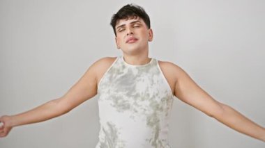 Genç adam, yorgun ama hala gülümsüyor, uykulu bir pozisyonda, elleri birbirine kenetlenmiş, gözleri kapalı bir şekilde rüyada yakalanıyor. Kolsuz bir tişört giyip, ıssız beyaz bir arka plana yaslanıyorsun..