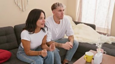 Neşeli bir adam ve kadın rahat bir oturma odasındaki kanepede oturup mutlu bir ilişkiyi somutlaştırıyorlar..