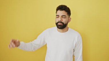 Saçları düzgün bir şekilde gülümseyen neşeli ve çekici genç adam sarı arka planda tek başına duruyor.