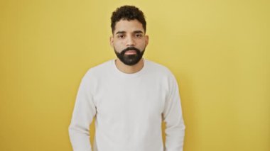 Sarı izole edilmiş arka plana karşı duran yakışıklı genç adam, dilini dışarı çıkarıyor, mutlu ve komik bir ifade takınıyor - saf mutluluk.!