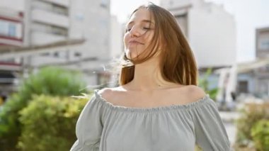 Sarışın kadın şehirde meditasyon yapıyor sakin bir şehir ortamında sakinliğini ve farkındalığını ifade ediyor..