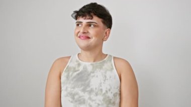 Neşeli genç bir adam, güvenli bir şekilde kolsuz bir tişört giyiyor, mutlu bir manzarayla orta düşünceyi yakalamış, beyaz izole bir arka plana bakarken gülümsüyor.