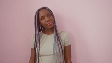 Hüsrana uğramış Afrikalı Amerikalı kadın, yaptığı hatayı fark ederek alnına tokat atıyor. Tüh! Bir şey unuttum! İzole edilmiş pembe bir arkaplanda dururken hafızası yine onu yanılttı..