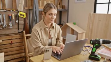 Neşeli sarışın kadın, marangozluk başarısı ile kendinden emin, dişlek bir gülümseme takınıyor.