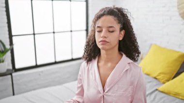 Sakin bir sabah, genç ve güzel bir İspanyol kadın dengesini bulur, pijamalarıyla yatağa oturur, meditasyon pozuna konsantre olur, evinde yoga egzersizi yapar..