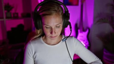 Akşamları canlı bir oyun odasında kulaklıklı, odaklanmış, beyaz bir kadın..