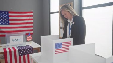 Sarışın bir kadın Amerikan oy kullanma merkezinde bizlerle birlikte oy veriyor.