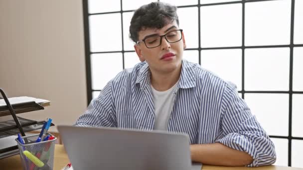 Молодий Чоловік Окулярах Працює Ноутбуці Сучасному Офісі Виглядає Втомленим Або — стокове відео