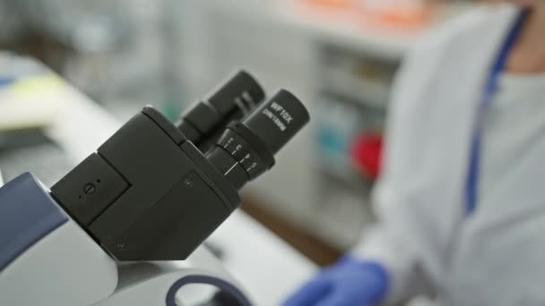 Soustředěná Žena Používající Mikroskop Laboratorním Prostředí Ochrannými Brýlemi Laboratorním Pláštěm — Stock video